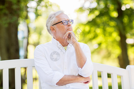 老,退休人们的体贴的老人戴着眼镜,坐夏季公园的长凳上夏天公园思想的老人图片