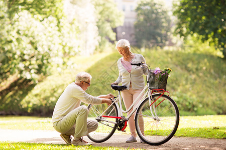积极的老,人生活方式的快乐的老夫妇与固定自行车夏季城市公园快乐的老夫妇夏季公园骑自行车背景图片