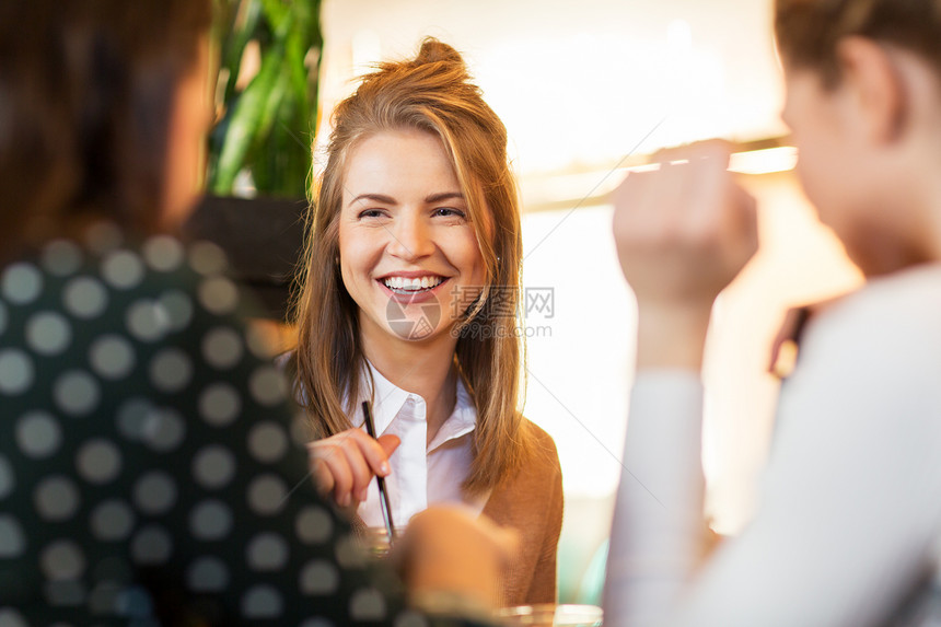 休闲人的快乐的女朋友坐咖啡馆餐馆里聊天快乐的朋友坐咖啡馆里聊天图片