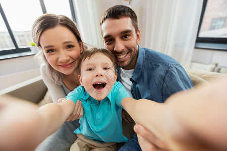 家庭,肖像人的快乐的小儿子与母亲父亲家里自拍幸福的家庭家里自拍图片