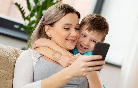 家庭,技术人的快乐的母亲小儿子与智能手机家里家里智能手机的幸福家庭图片