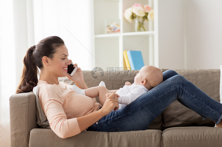 家庭,技术,母亲人的快乐的母亲,小男孩躺沙发上,打电话家里的智能手机母亲带着婴儿家里打电话给智能手机图片