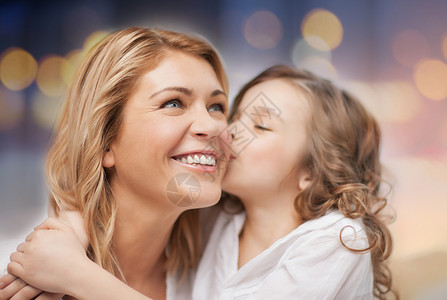 家庭母亲的快乐的母亲女儿拥抱亲吻假日灯光背景快乐的母亲女儿拥抱亲吻图片