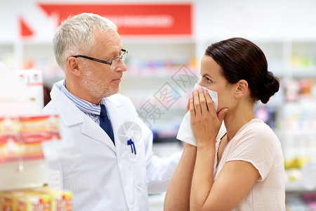 医学,医疗人的高级药剂师与药物女客户感冒鼻子药房药房的药剂师生病的顾客图片