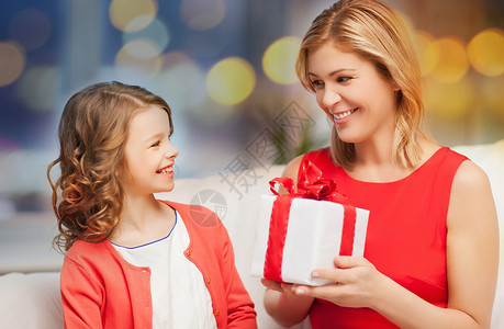 诞节,家庭人的快乐的母亲女儿与礼品盒节日灯的背景带着礼品盒的快乐母女图片