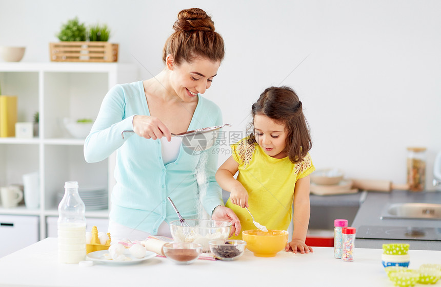 家庭,烹饪,烘焙人们的快乐的母亲小女儿用筛子筛粉家里厨房快乐的母女家烘焙图片