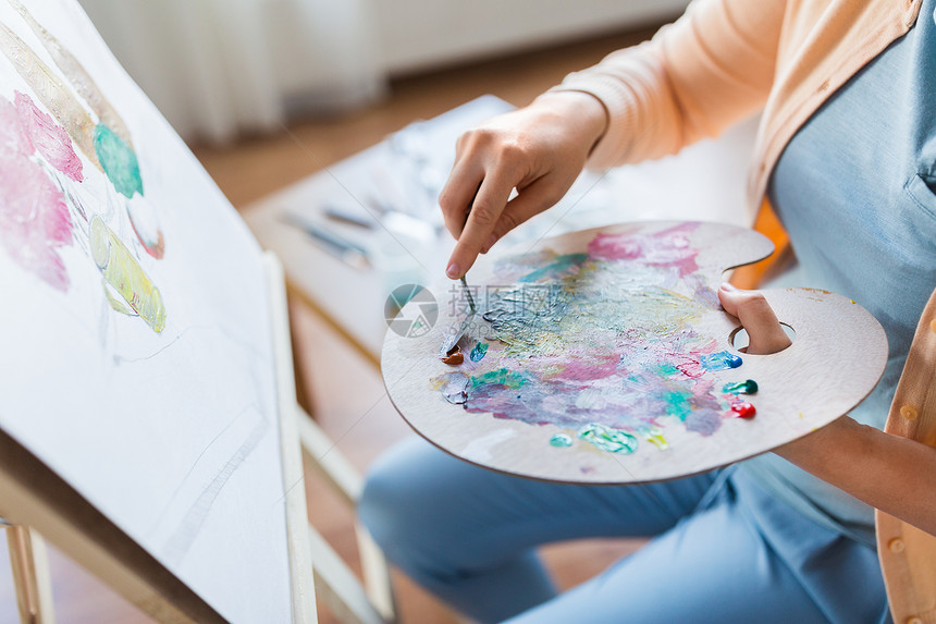 艺术,创造力人的接近艺术家妇女与调色板刀画生活画室的画架上艺术家艺术工作室用调色板刀画图片