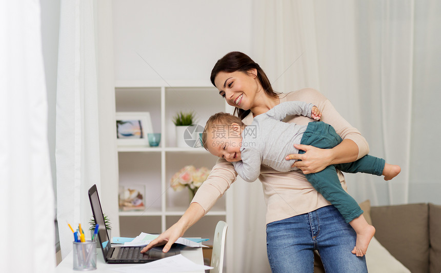 母亲,多任务,家庭技术快乐的母亲与婴儿,笔记本电脑文件工作家里快乐的母亲带着孩子笔记本电脑家工作图片