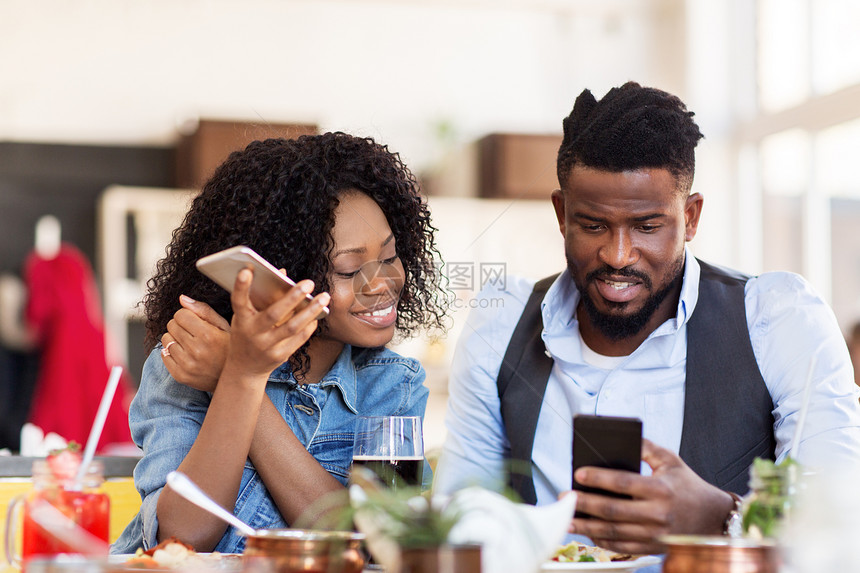 休闲,技术人的快乐的男人女人与智能手机餐厅吃饭快乐的男人女人餐厅用智能手机图片