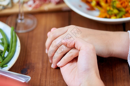 人,关系饮食人的手坐桌子上与食物祈祷饭前饭前人们餐桌上祈祷的手图片