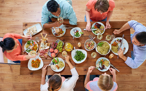 饮食休闲群人餐桌上吃晚饭群人桌子上吃食物背景图片