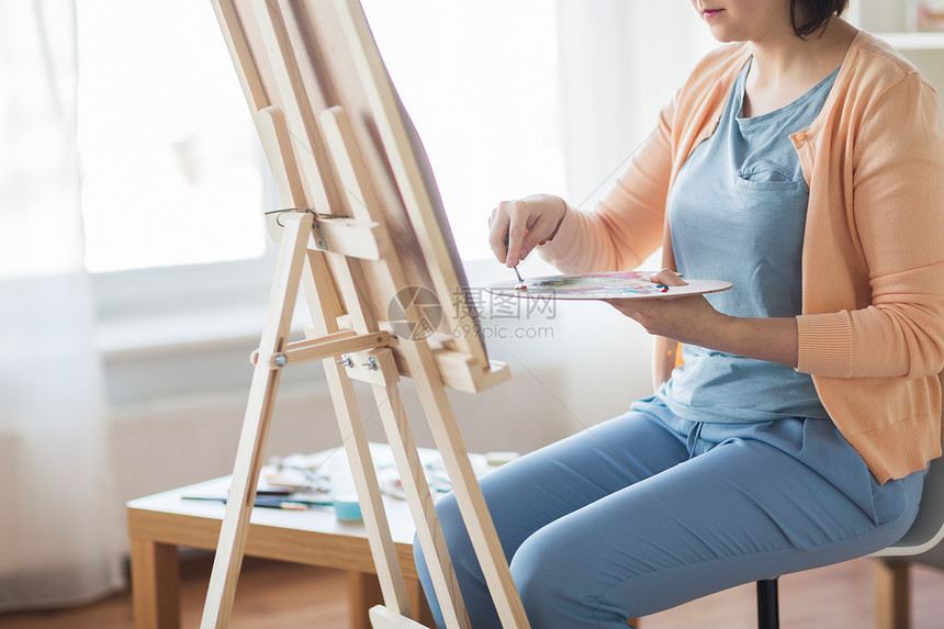 艺术,创造力人的艺术家妇女与调色板刀画架工作室艺术家艺术工作室用调色板刀画图片