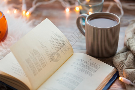 热灯潮湿舒适的家庭书杯咖啡热巧克力桌子上桌子上书杯咖啡热巧克力背景