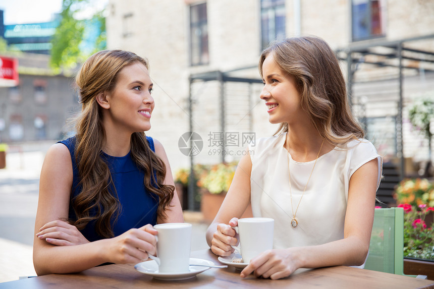 沟通,友谊人的快乐的轻女户外咖啡馆喝咖啡快乐的轻女人户外咖啡馆喝咖啡图片