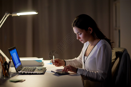 商业,会计,过度工作,截止日期人的妇女与税务表格计算器夜间办公室工作晚上办公室计算器论文的女人背景图片