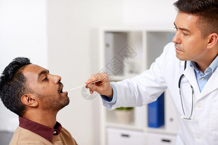 医学,保健喉学医生喉科医生与压舌器检查男的喉咙临床医生诊所检查病人的喉咙图片