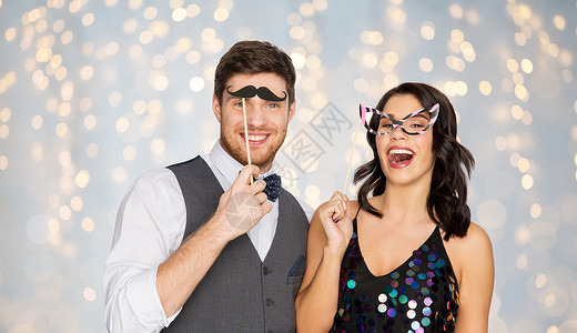 庆祝,乐趣节日的快乐的夫妇与派道具节日灯的背景快乐的夫妇派道具玩得开心图片