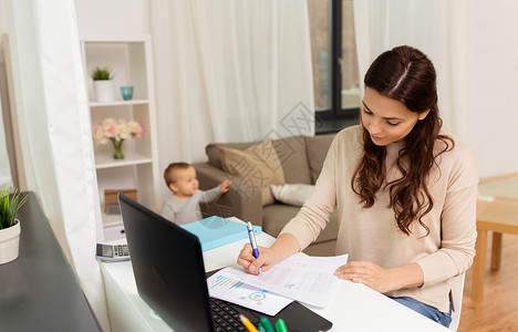 母亲,多任务,家庭人的快乐的母亲与婴儿,文件笔记本电脑家里工作快乐的母亲带着孩子文件家工作背景图片