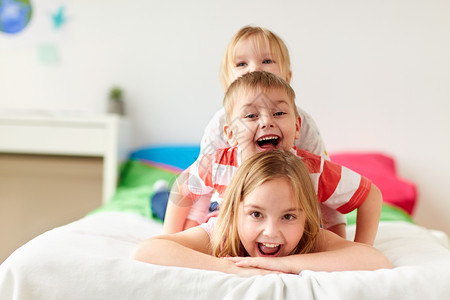 童,休闲家庭快乐的孩子家里的床上玩快乐的小孩子们家睡觉玩得很开心图片