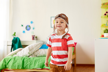 童,想象梦想的快乐的小男孩飞行员帽子玩游戏家快乐的小男孩戴着领航帽家玩图片