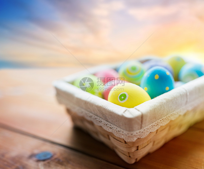 复活节,假日,传统象彩色鸡蛋柳条篮子木制桌子上的天空背景篮子里彩色复活节彩蛋图片