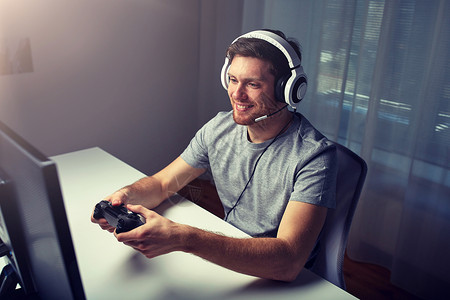 技术,游戏,娱乐活动,让们的游戏人的快乐的轻人耳机与控制器游戏家里玩电脑游戏流媒体播放演练视频戴耳机的男人背景图片