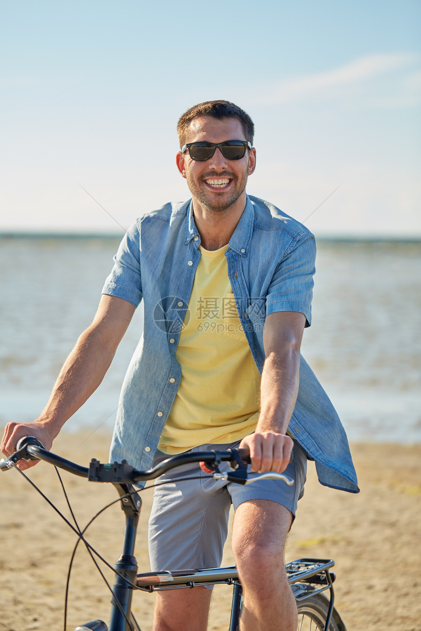 人们,休闲生活方式的快乐的轻人戴着太阳镜骑自行车沿着夏天的海滩快乐的人骑自行车沿着夏天的海滩图片