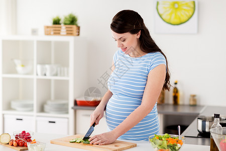 健康饮食,怀孕人的孕妇烹饪蔬菜沙拉切萝卜家厨房孕妇家煮蔬菜图片