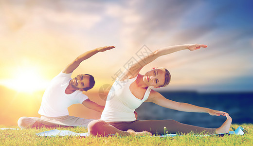 健身人们的夫妇户外的垫子上瑜伽练,海洋背景上夫妇户外瑜伽练图片