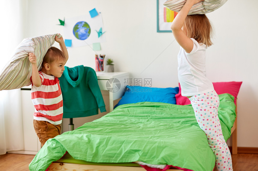童,休闲人的快乐的孩子家里靠枕头玩耍战斗孩子们家靠枕头玩耍打架图片