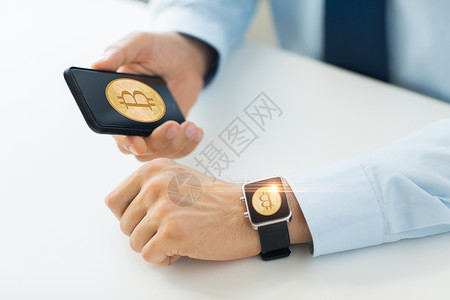 戴智能手表与比特币屏幕上智能手机智能手表上的比特币图片