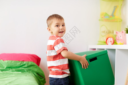 童,休闲人的快乐的小男孩与玩具箱家里快乐的小男孩家里玩具盒图片