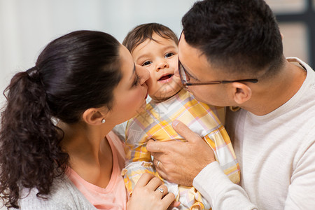 家庭,父母人的快乐的母亲父亲亲吻婴儿的女儿快乐的母亲父亲亲吻婴儿的女儿图片
