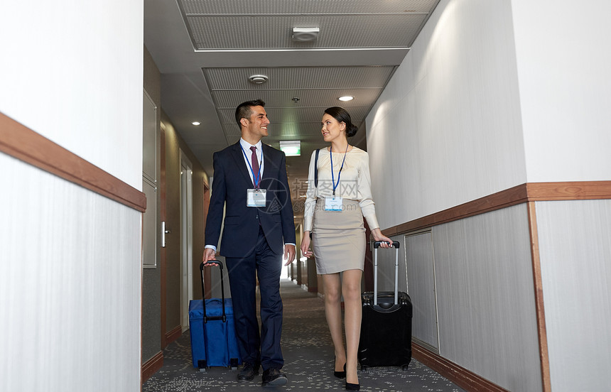 商务旅行人的男人女人带着旅行袋会议章酒店走廊商务队酒店走廊带旅行袋图片