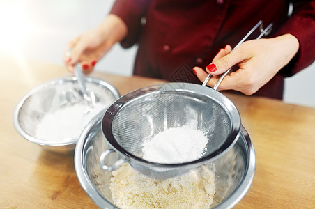 筛分烹饪食物,烘焙人们的厨师与过滤器筛粉碗制作糊厨师用粉碗里糊背景