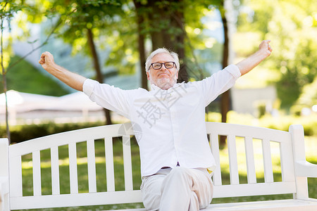 老人人的快乐的老人戴着眼镜坐夏季公园戴眼镜的快乐老人坐夏天的公园里图片