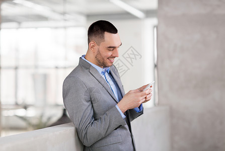 商务人士,技术企业微笑的商人与斯马福涅办公室微笑的商人办公室用手机图片