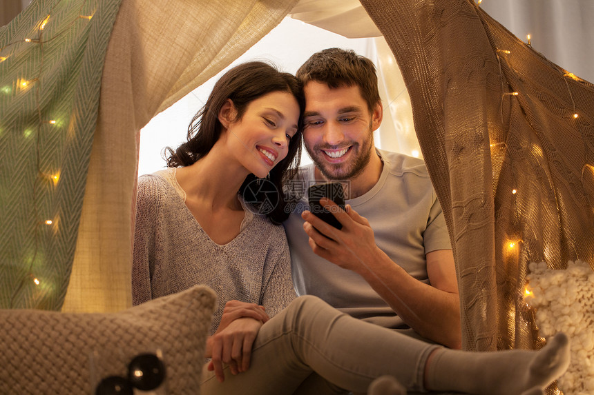 休闲,技术人的幸福的夫妇与智能手机孩子帐篷家幸福的夫妇孩子们的帐篷里玩智能手机图片