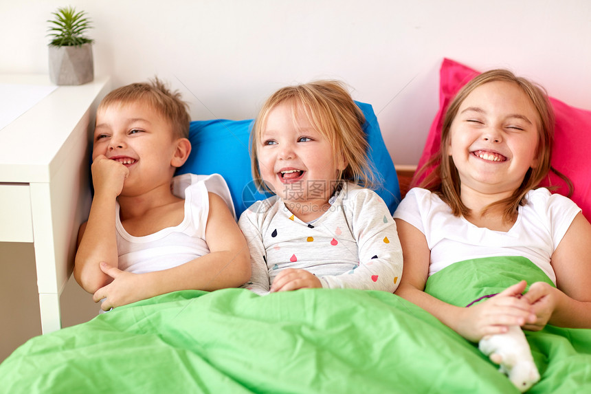 童,休闲家庭快乐的孩子家里的床上玩快乐的小孩子们家睡觉玩得很开心图片