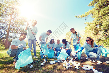 志愿服务慈善人生态理念公园内群带垃圾袋耙清理区域的快乐志愿者志愿者用垃圾袋清洁公园区域志愿者用垃圾袋清洁公园图片