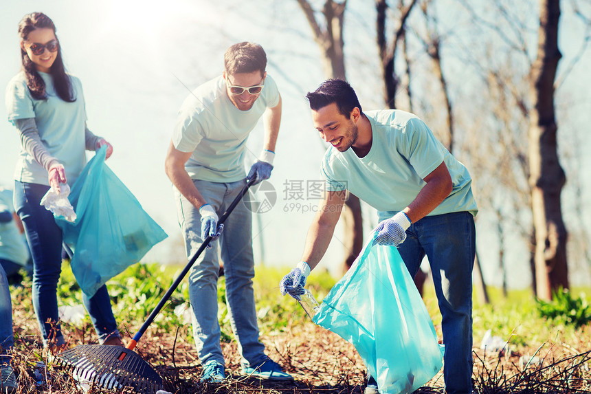 志愿服务慈善清洁人与生态理念公园垃圾袋清洁区的群快乐志愿者志愿者用垃圾袋清洁公园区域志愿者用垃圾袋清洁公园区域图片