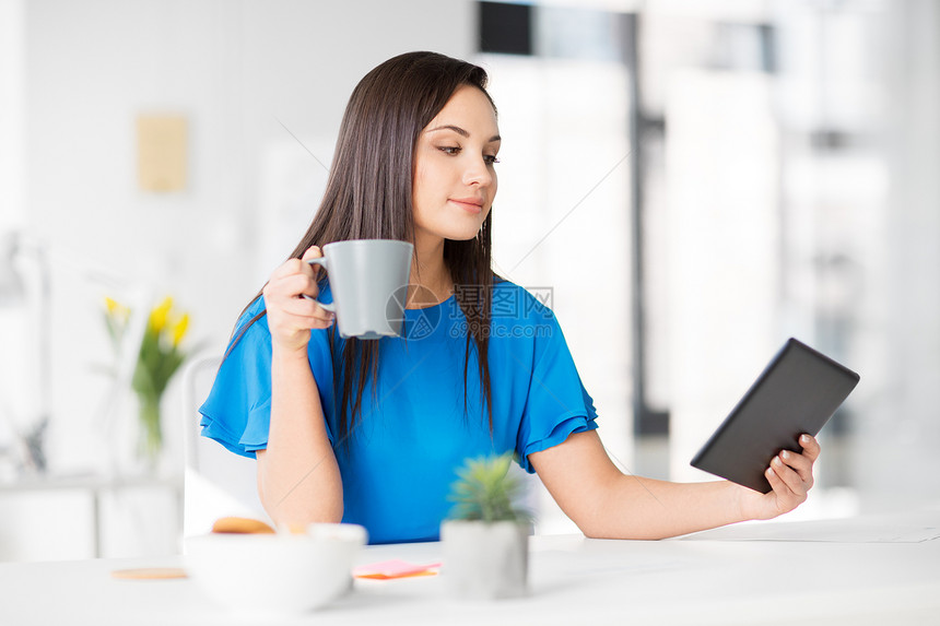 商业,技术人的女商人用平板电脑办公室喝咖啡办公室里平板电脑咖啡的女商人办公室里平板电脑咖啡的女商人图片