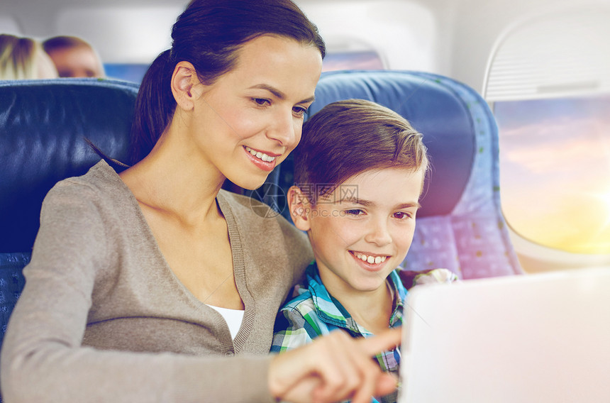 旅行,旅游,家庭技术快乐的母亲儿子与平板电脑电脑坐飞机上的舷窗背景快乐的家庭与平板电脑坐飞机上快乐的家庭与图片