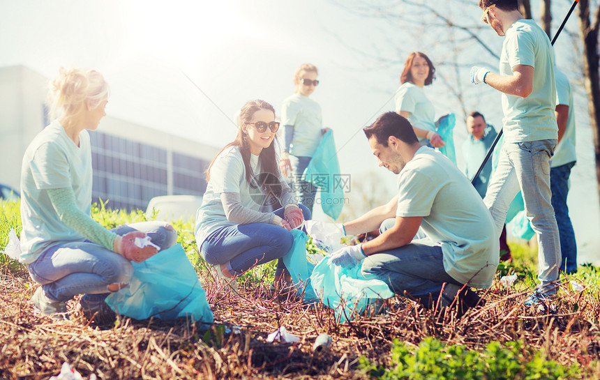 志愿服务慈善清洁人与生态理念公园垃圾袋清洁区的群快乐志愿者志愿者用垃圾袋清洁公园区域志愿者用垃圾袋清洁公园区域图片