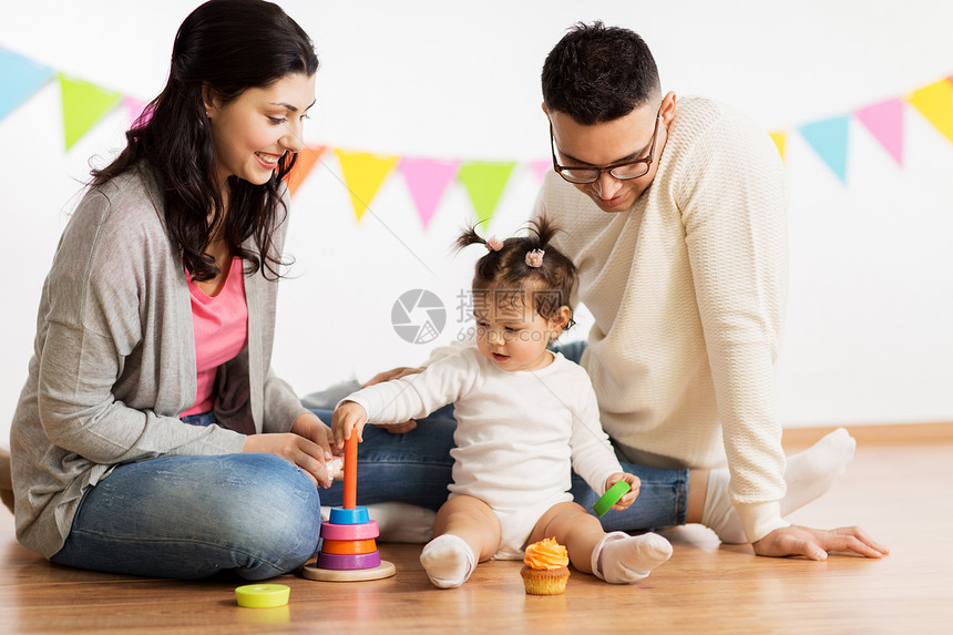 家庭,假期人的快乐的母亲,父亲小女儿玩环形金字塔婴儿玩具生日聚会上带着父母玩金字塔玩具的女婴带着父母玩金字塔图片