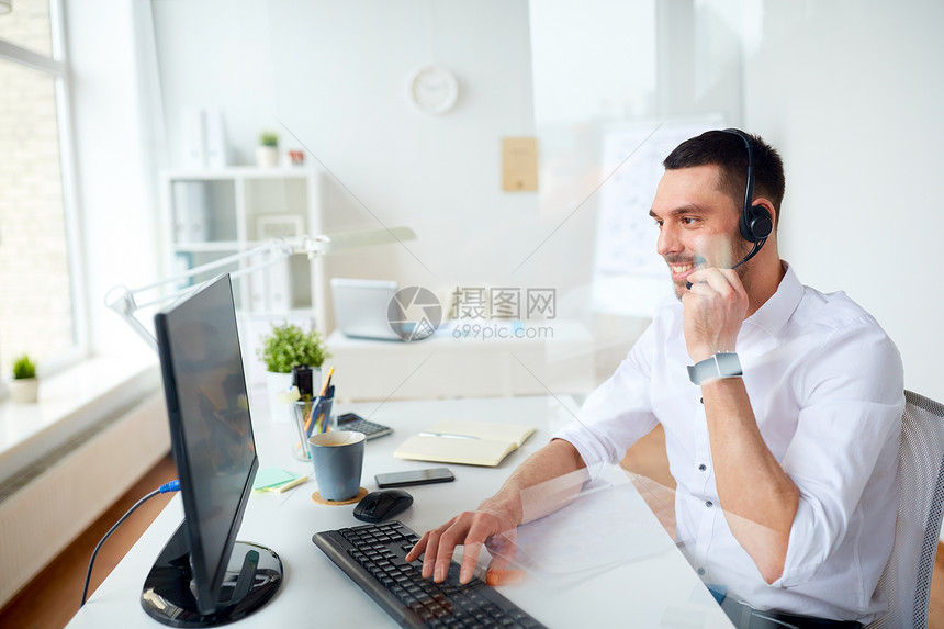 沟通,商业,人技术微笑的商人帮助热线运营商与耳机电脑打字办公室办公室带耳机电脑的商人办公室带耳机电图片
