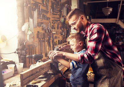 家庭木工木工人的父亲小儿子车间用木板飞机父亲儿子车间用飞机刨木父亲儿子车间用飞机刨木背景图片