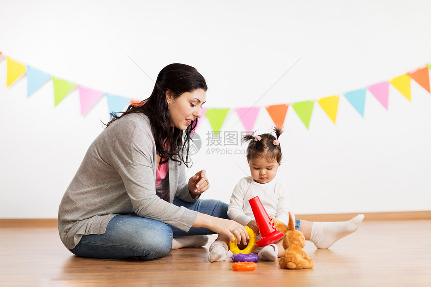 家庭,假期人的快乐的母亲小女儿玩环形金字塔婴儿玩具生日聚会上母女玩金字塔玩具母女玩金字塔玩具图片