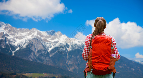 旅行,旅游徒步旅行的轻的女人带着背包阿尔卑斯山的背景女人背着背包阿尔卑斯山上女人背着背包阿尔卑斯山上图片