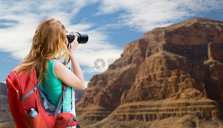 旅行,旅游摄影快乐的轻妇女背包相机拍摄大峡谷公园的背景大峡谷带背包照相机的女人大峡谷带背包照相图片